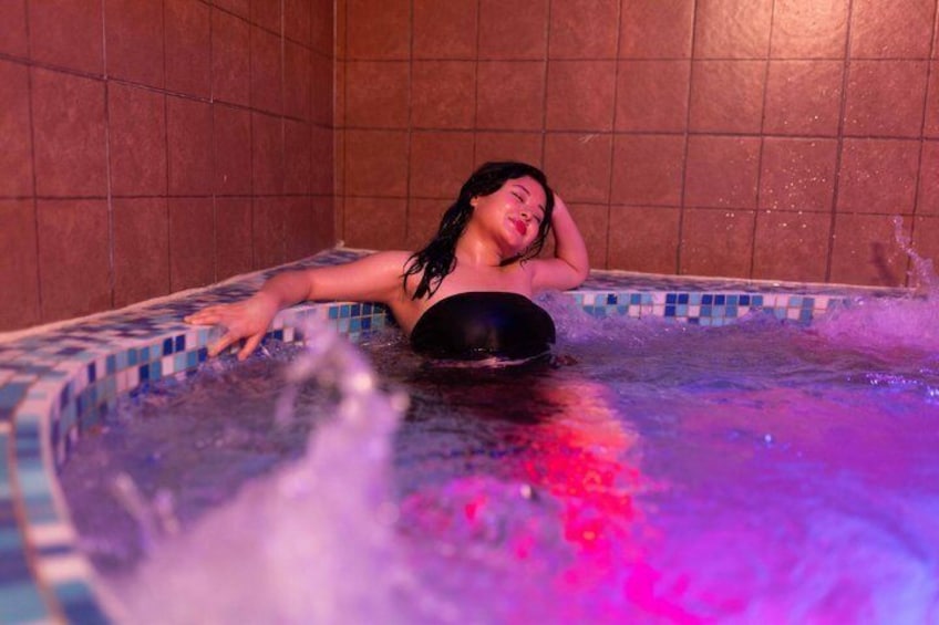 A person in a hot tub with water jets. 3