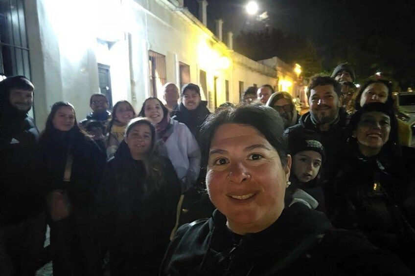 A group of people gathered on a street at night. 2