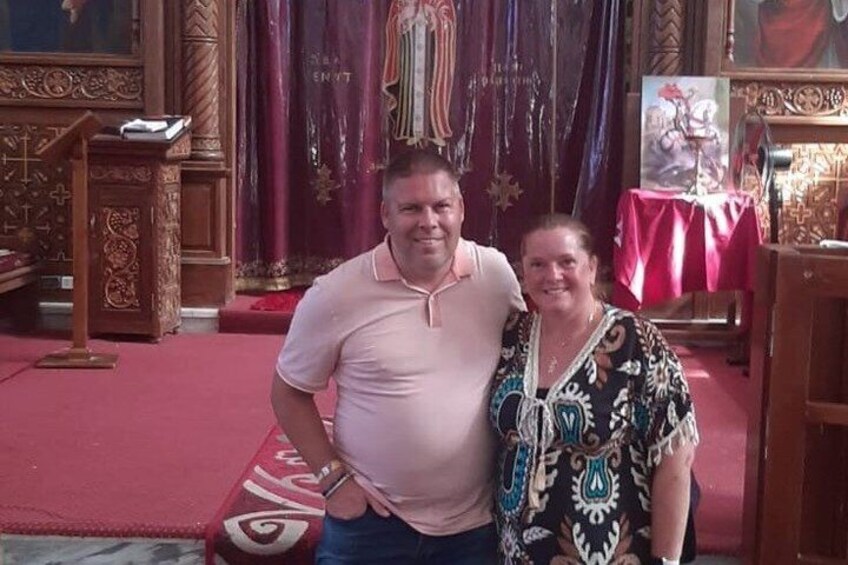 A person standing in a church with ornate woodwork and a red carpet. 4