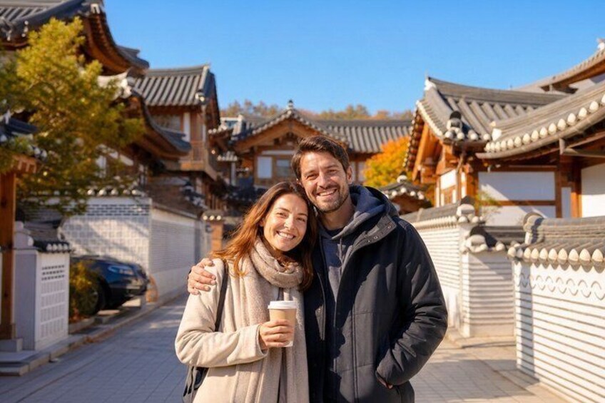 A couple standing in front of traditional Korean architecture with a clear sky. 5