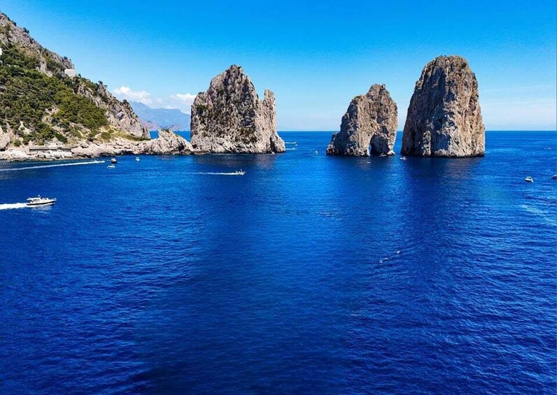 A coastal landscape with rocky formations and a clear blue sea. 3