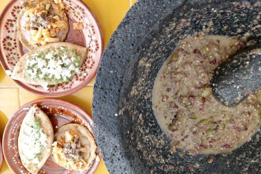 Three bowls of food with a mortar and pestle. 5
