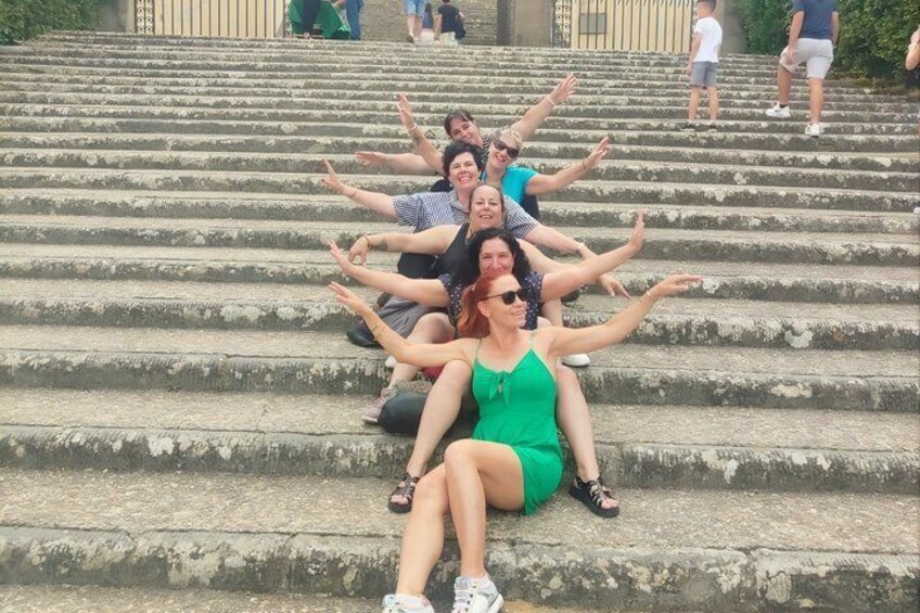 A group of people sitting on stone steps with their arms spread out. 3
