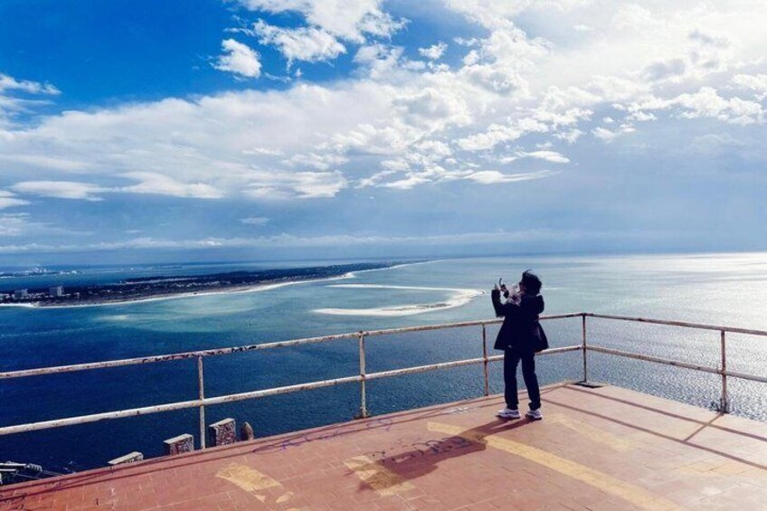 A person taking a photo of the ocean from a high vantage point. 4