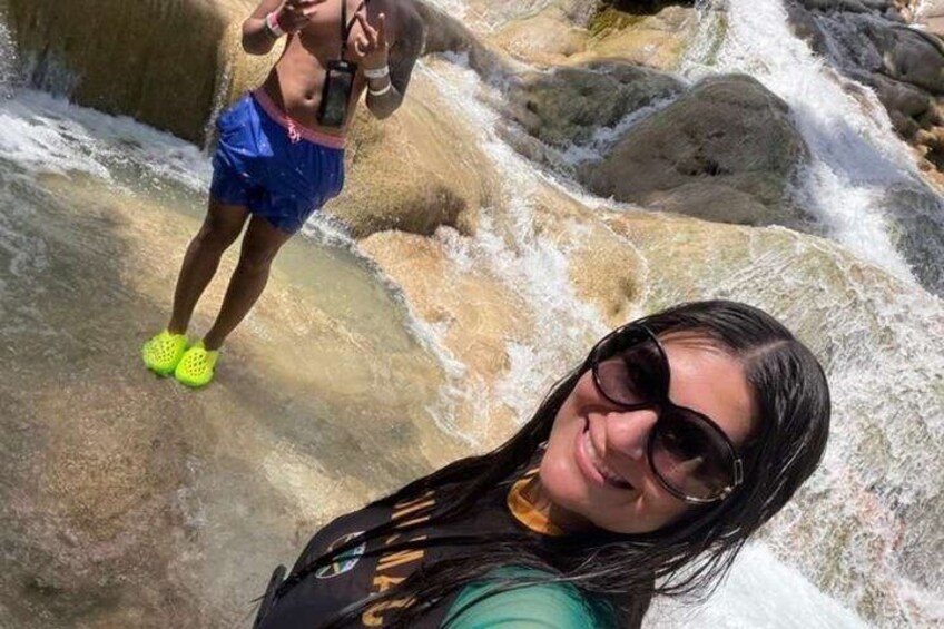 A person taking a selfie with a waterfall in the background. 3