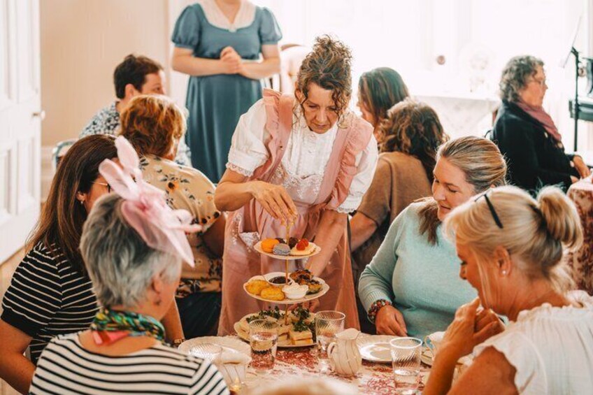 A group of people at a buffet with a server serving food. 1