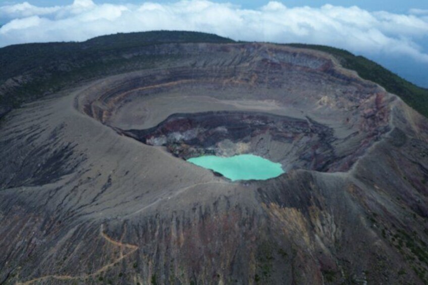 A large, circular crater with a turquoise lake at its center. 1