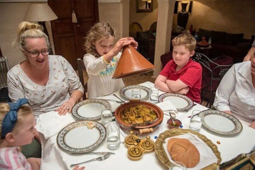 A family dining with a traditional Moroccan tagine on the table. 2