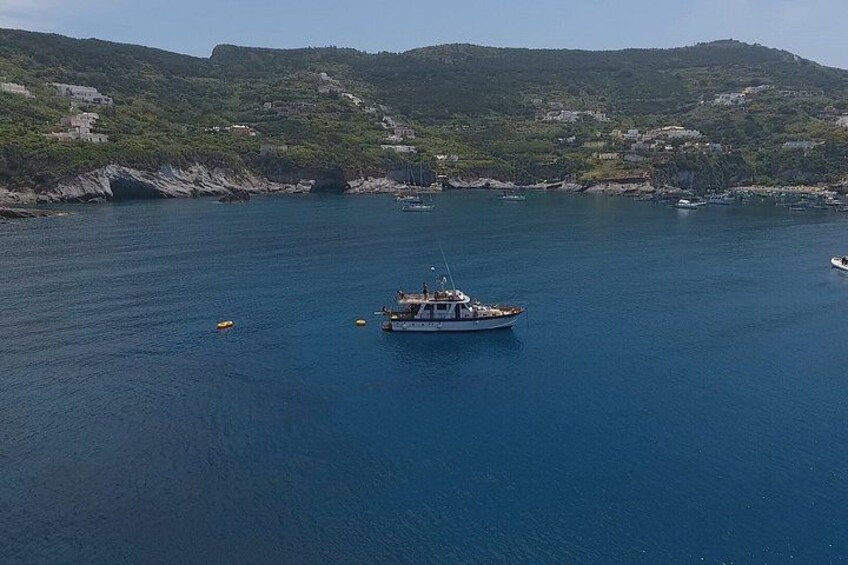 A boat on a calm sea with a hilly landscape in the background. 3