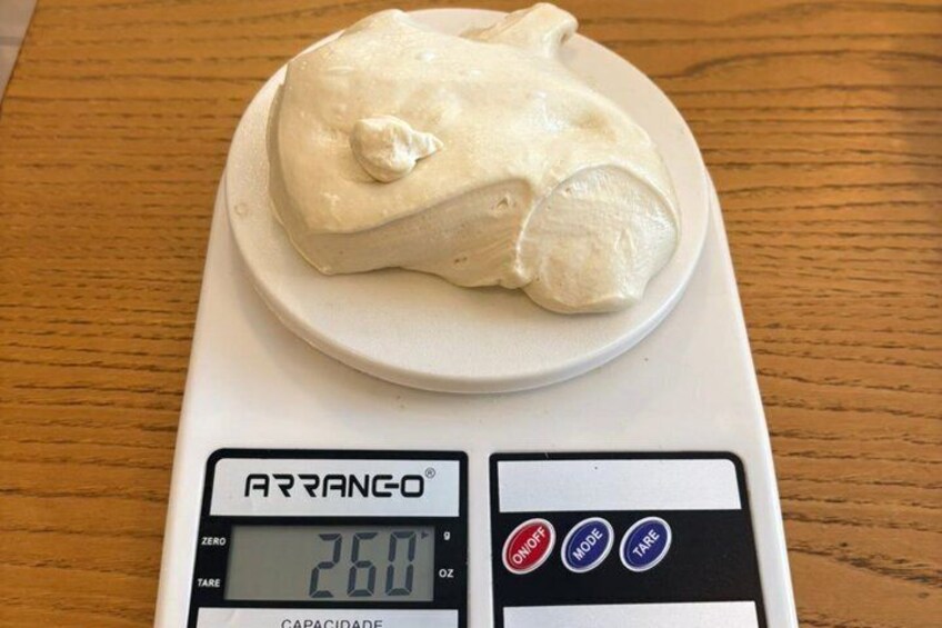 A digital kitchen scale with a white object on it, displaying a weight of 260 grams. 4