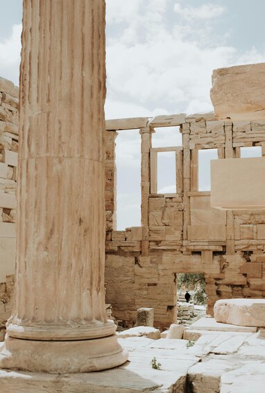 Ancient ruins with a prominent column and stone walls. 4