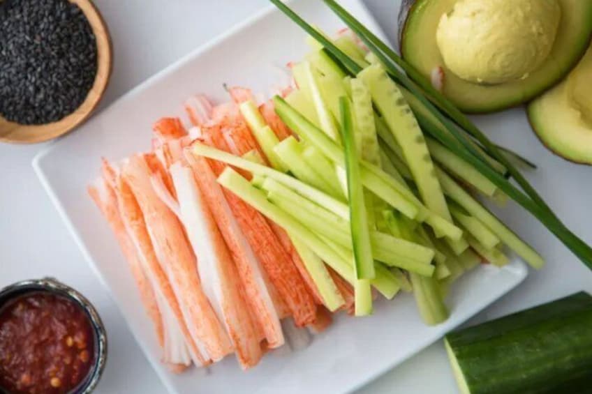 A plate of sliced vegetables and a bowl of sauce. 3