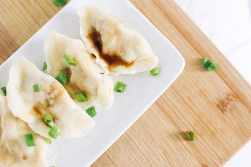 A plate of dumplings garnished with chopped green onions. 2
