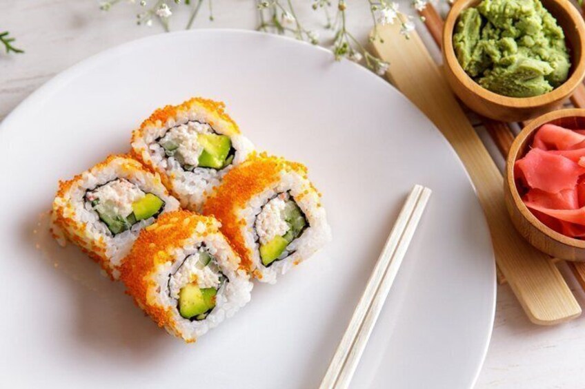 A plate with sushi rolls, a bowl of guacamole, and a bowl of pickled salmon. 3
