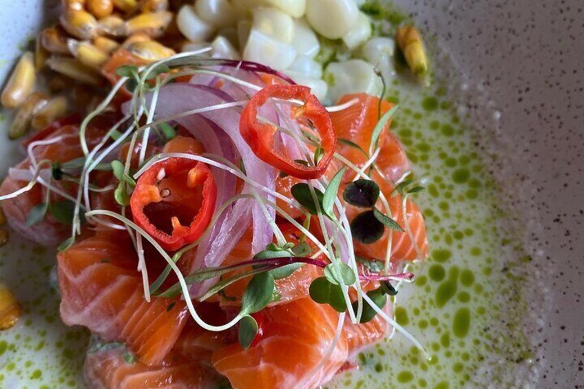 A dish of smoked salmon with red onion, sprouts, and black olives. 1