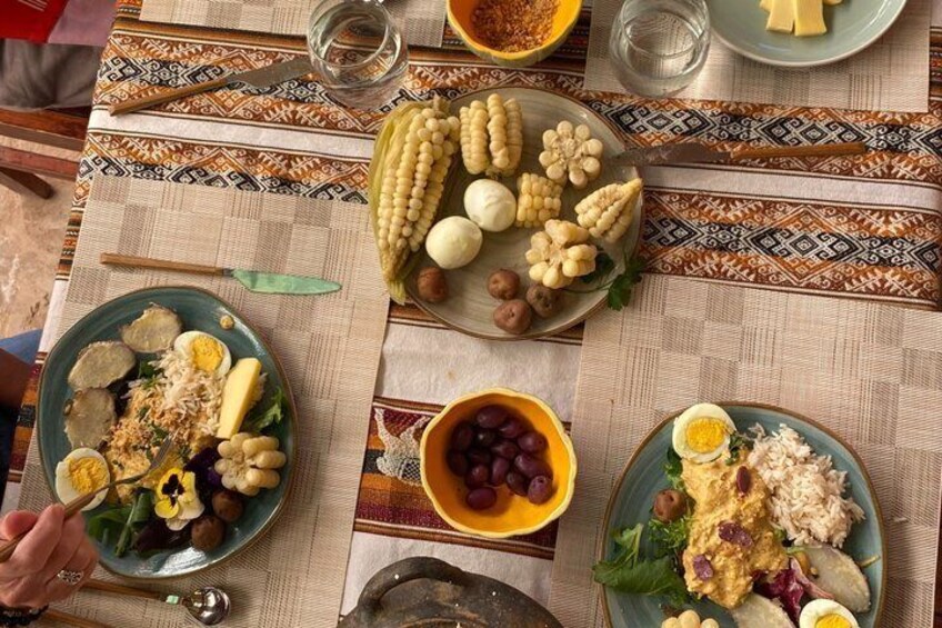 A table with various dishes including corn on the cob, eggs, and a bowl of grapes. 5