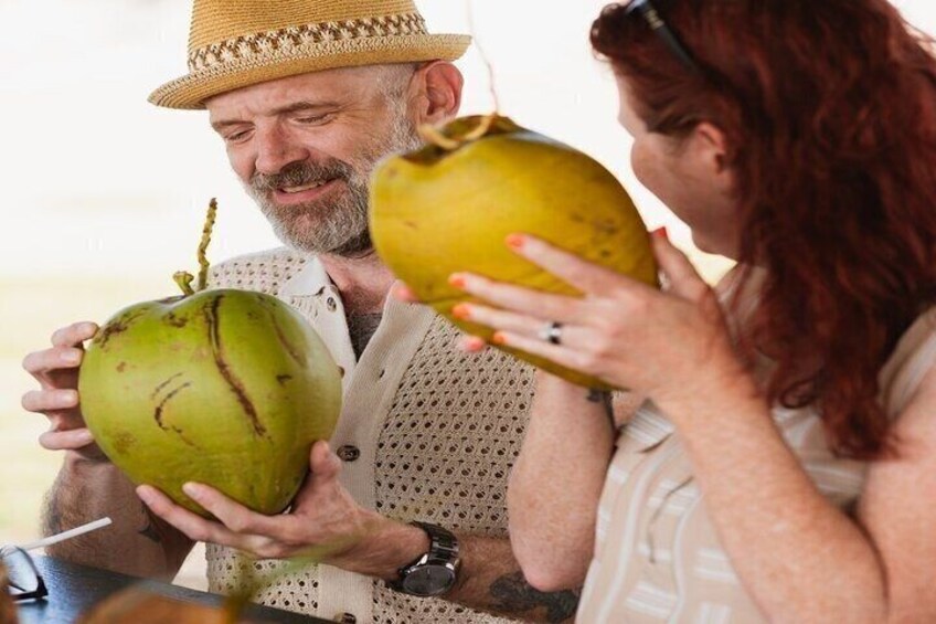 Two people holding coconuts. 5