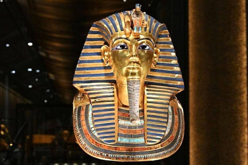 A golden pharaoh's head with a striped headdress and a cobra figure. 1