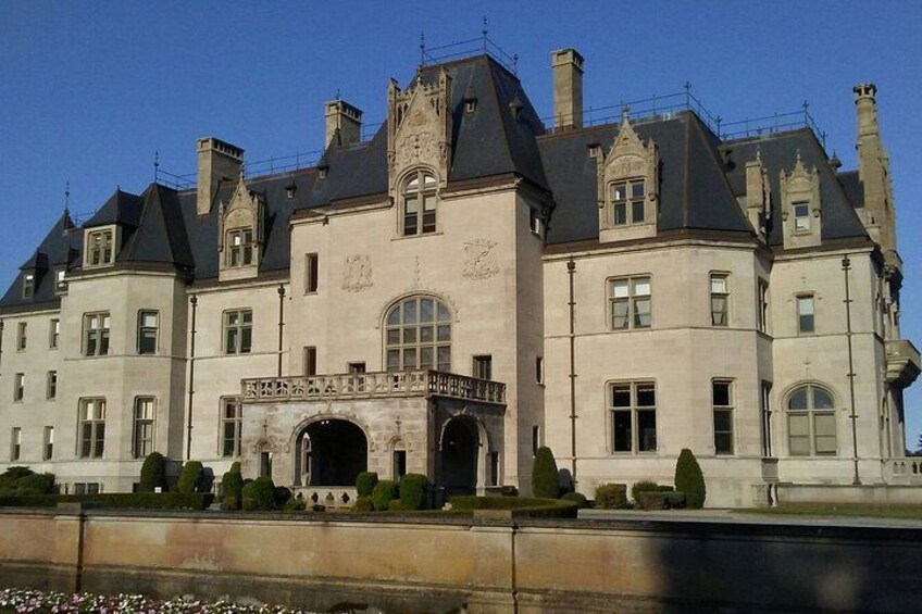 A large, historic building with a prominent archway and multiple chimneys. 2
