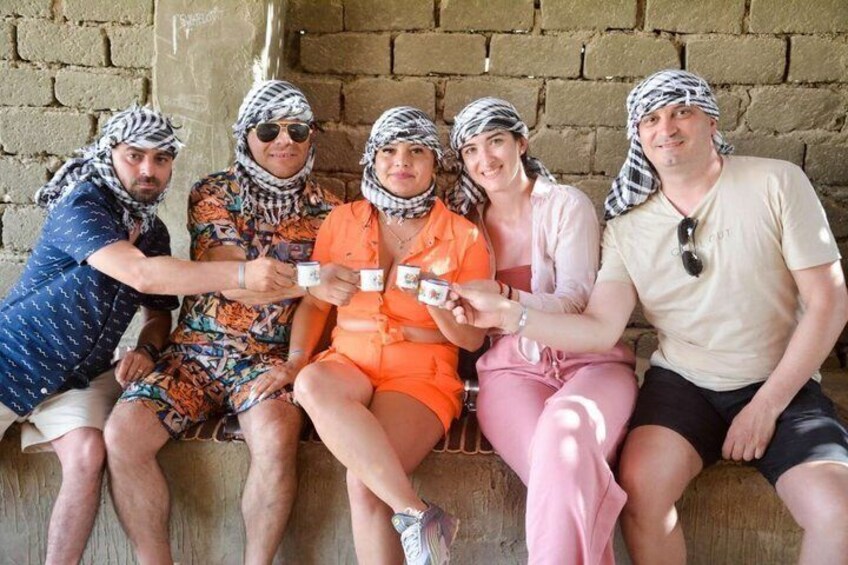 A group of people sitting on a bench against a brick wall. 2