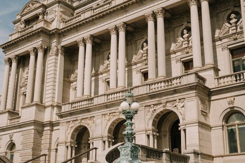 A classical building with columns, arches, and statues. 2