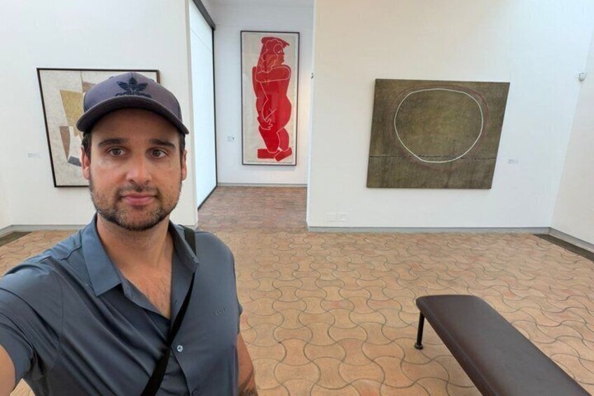 An art gallery with abstract paintings on the walls and a patterned floor. 5