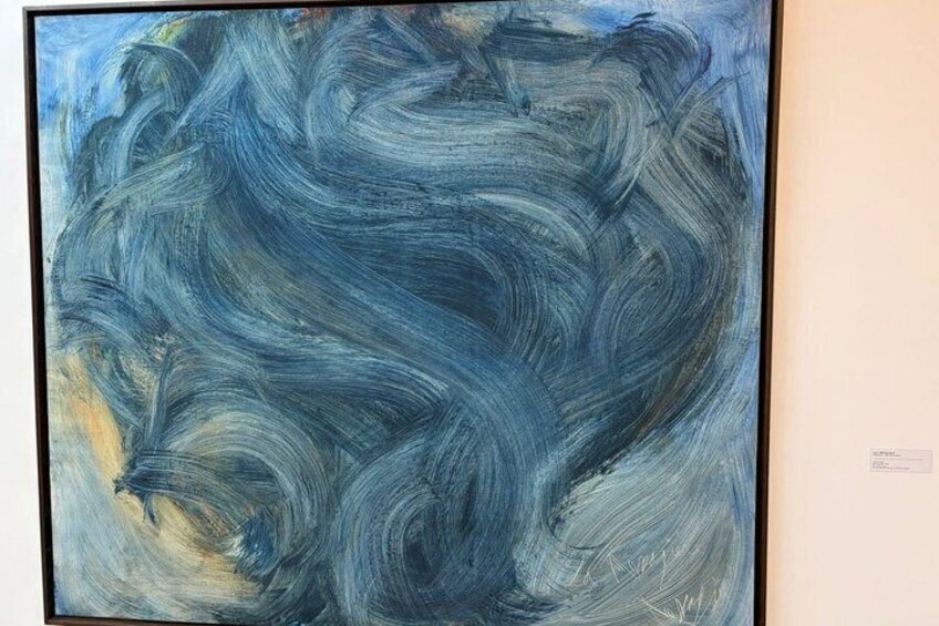 A large abstract painting with swirling blue and gray brushstrokes. 2