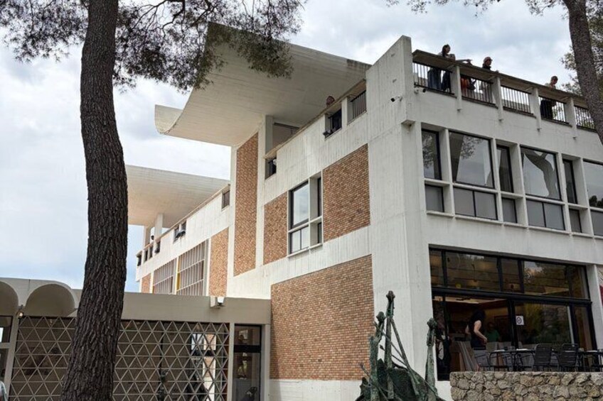 A modern building with a flat roof, brick facade, and large windows. 1