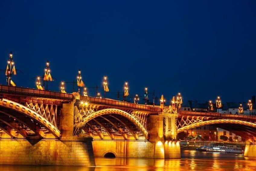 A brightly lit bridge with multiple arches and street lamps. 2