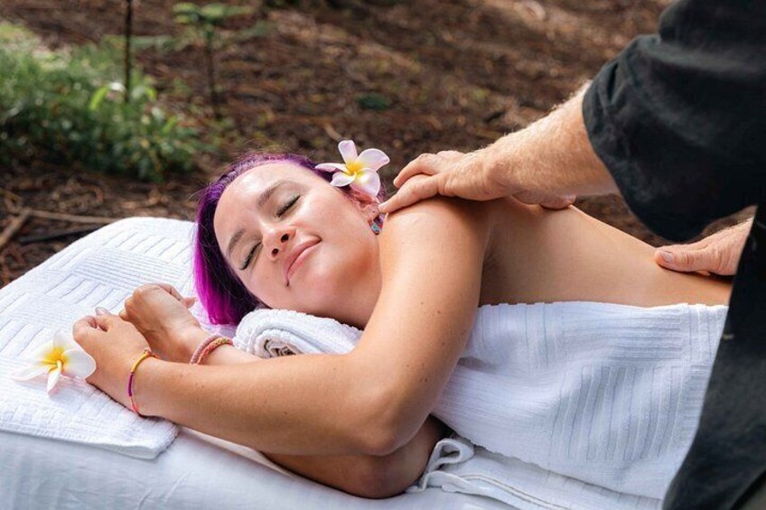 A person receiving a massage with flowers on their head. 3