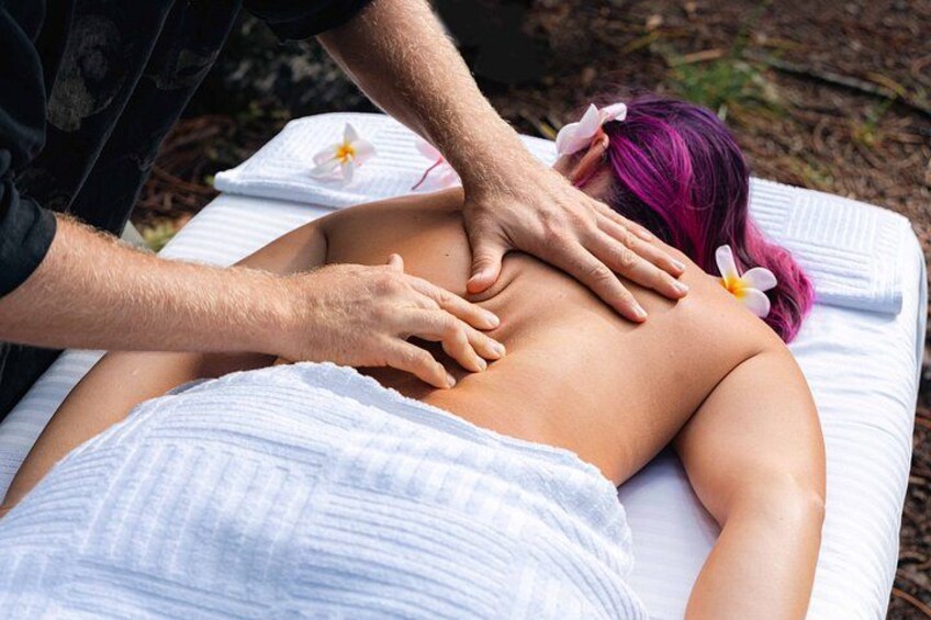 A person receiving a back massage outdoors. 2