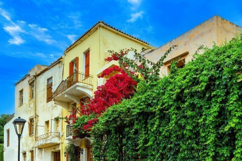 A yellow building with red flowers and green foliage. 3