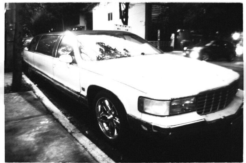 A white car parked on a street at night. 5