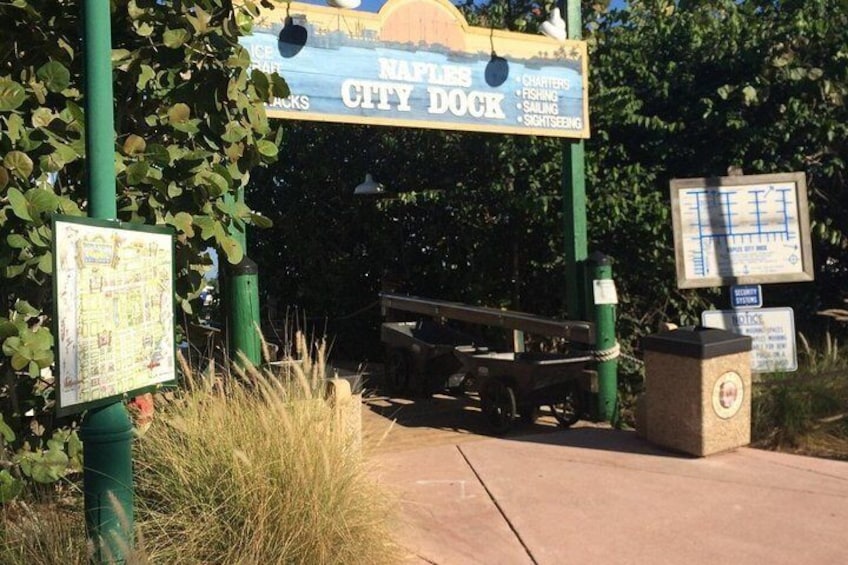 A sign for the Naples City Dock with a map and a list of activities like fishing and sightseeing. 3