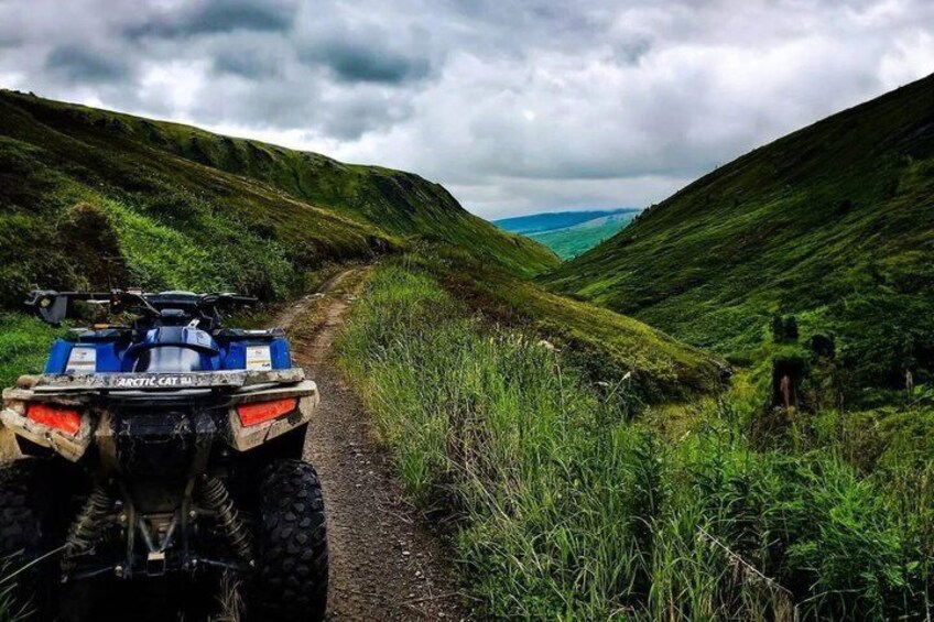 An ATV on a dirt path in a hilly area. 4