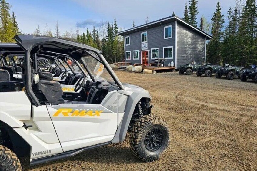 A white off-road vehicle with 'RMAX' branding parked on a gravel surface. 4