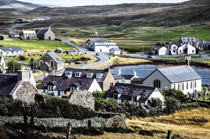 A coastal village with houses, a road, and a river. 3