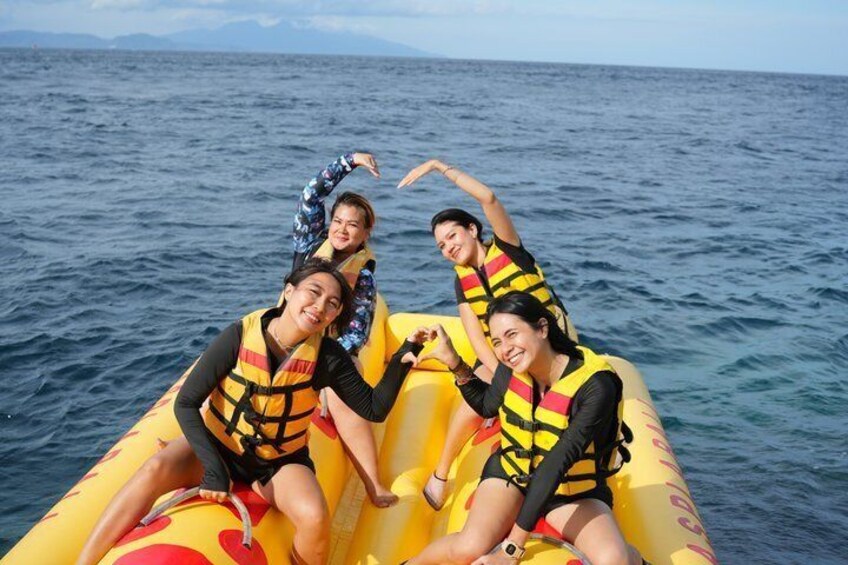 Four people on a yellow inflatable raft in the ocean. 2