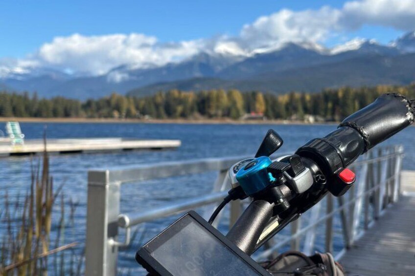 A kayak on a dock with a lake and mountains in the background. 5