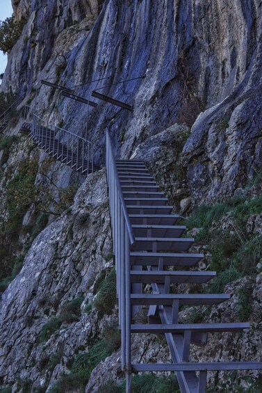 A metal staircase ascending a rocky mountain. 4
