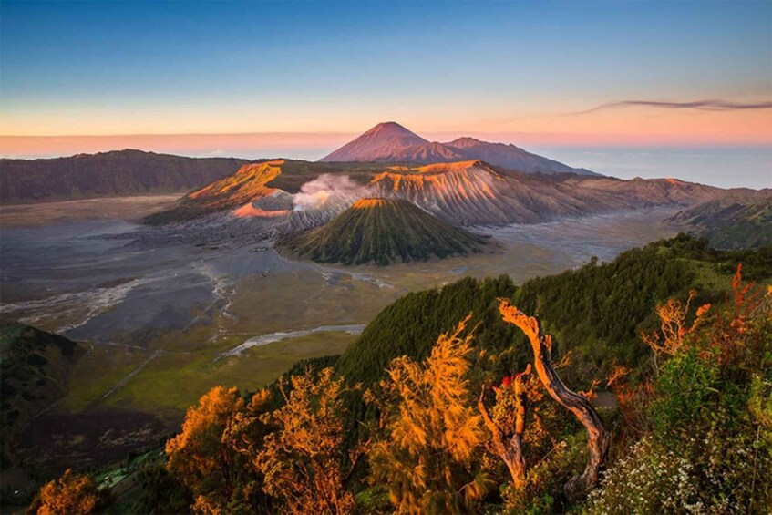 A volcanic landscape with a prominent mountain, a river, and surrounding greenery. 1