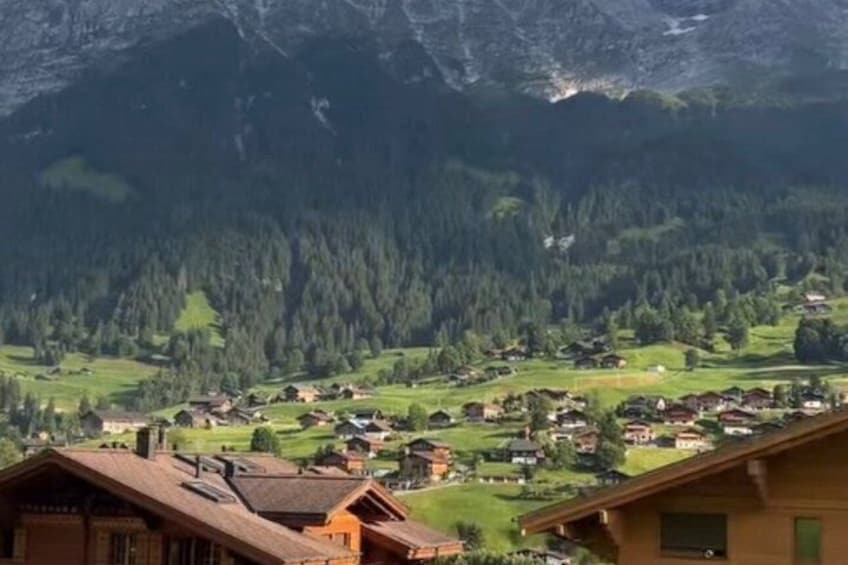 A mountain village with houses, forested hills, and a mountain backdrop. 2