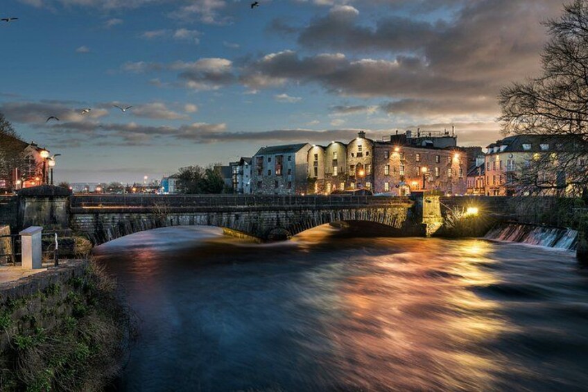 A river flowing under a bridge with buildings on the opposite bank. 5