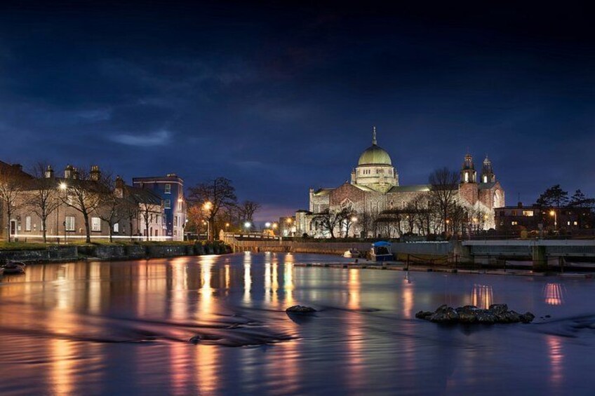 A nighttime view of a cityscape with a prominent domed building reflecting on a calm body of water. 3