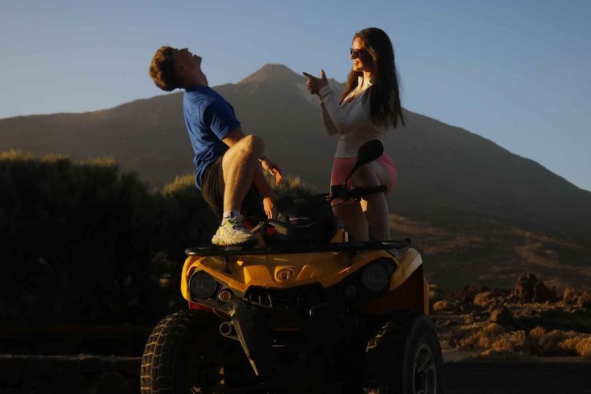Two people on an ATV with a mountainous landscape in the background. 5