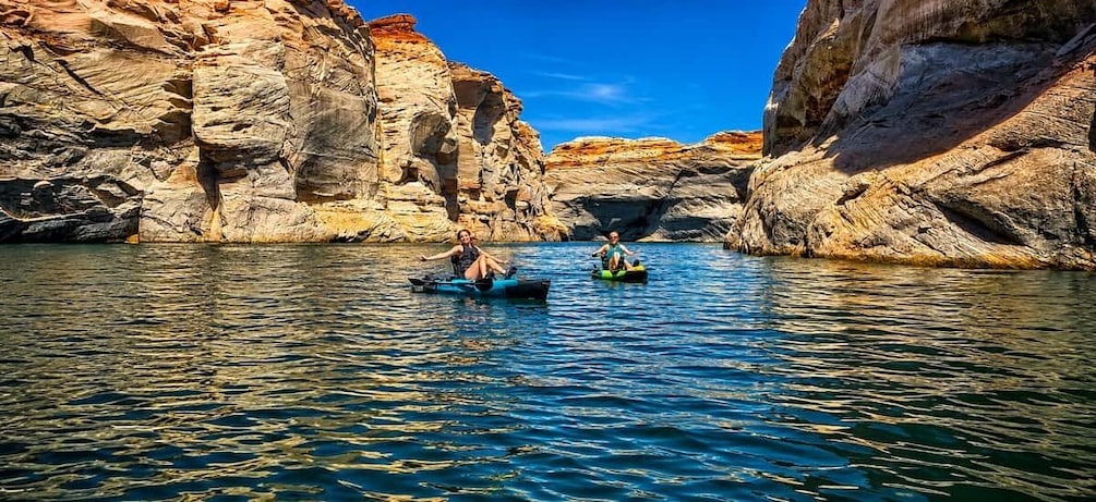 Two people kayaking in a narrow canyon with rocky cliffs. 3