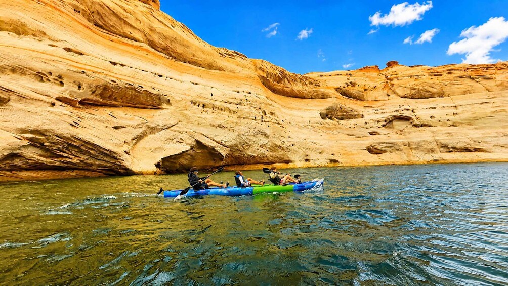 A group of people kayaking on a river with a rocky canyon in the background. 2
