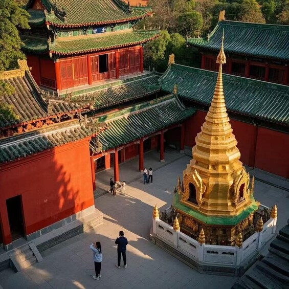 A traditional Chinese temple complex with ornate architecture, including a prominent golden stupa and red-roofed buildings. 4