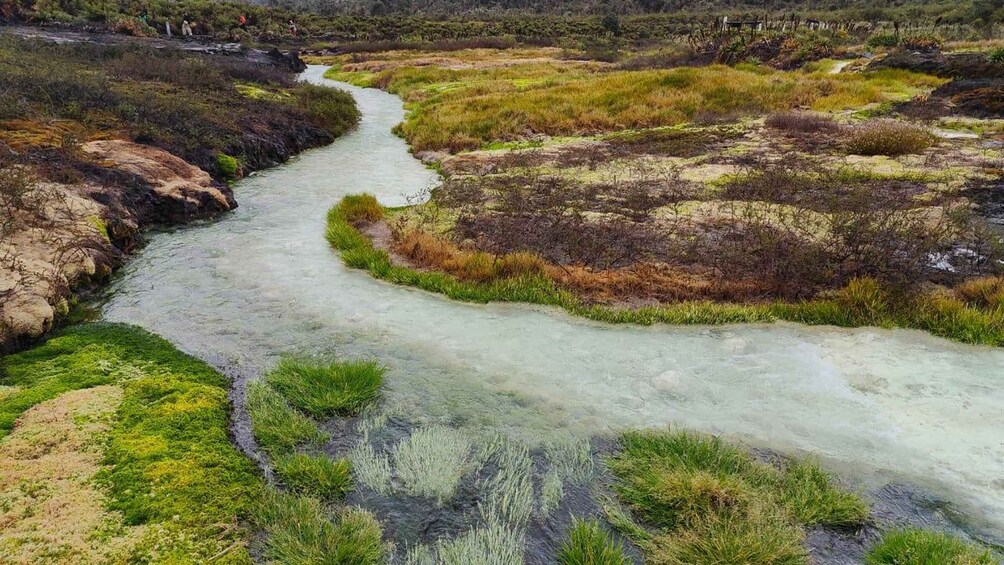 A river winding through a grassy landscape with rocky outcrops. 3