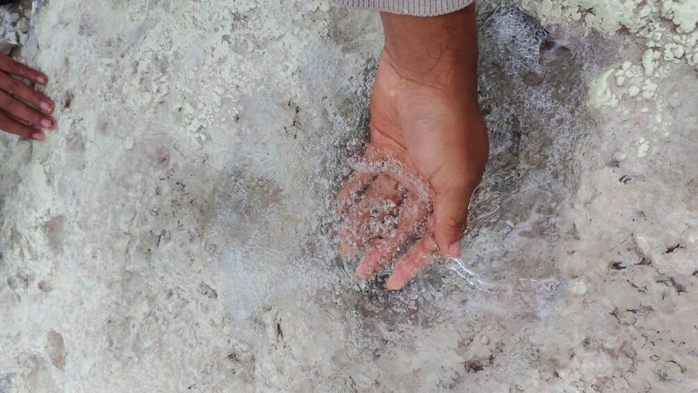 A hand submerged in water with bubbles, indicating a possible underwater activity. 2